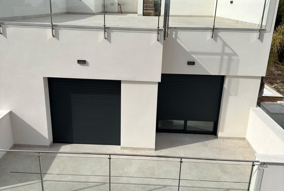 Bright, modern three-bedroom villa exterior in La Nucia, Costa Blanca featuring sleek glass balconies and mountain views.