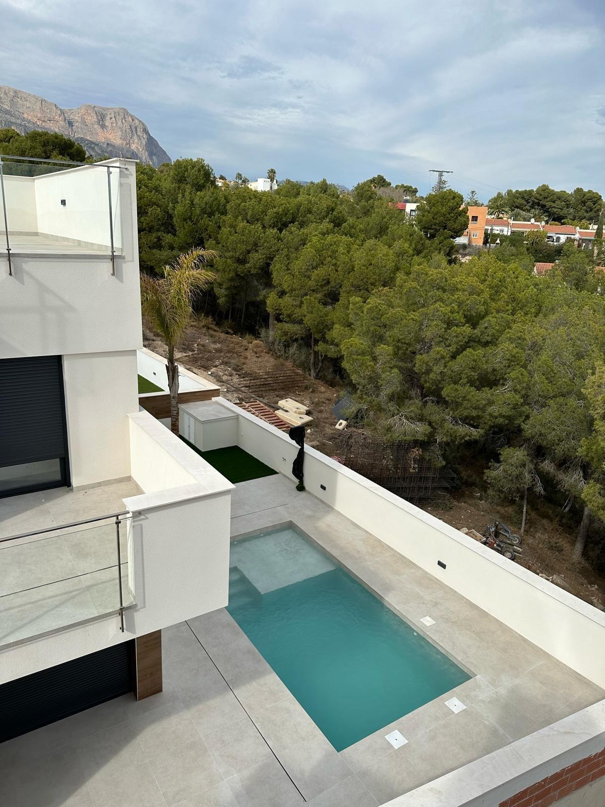 Sun-drenched modern 3-bedroom villa with private pool and sleek terrace overlooking lush greenery in La Nucia, Costa Blanca.
