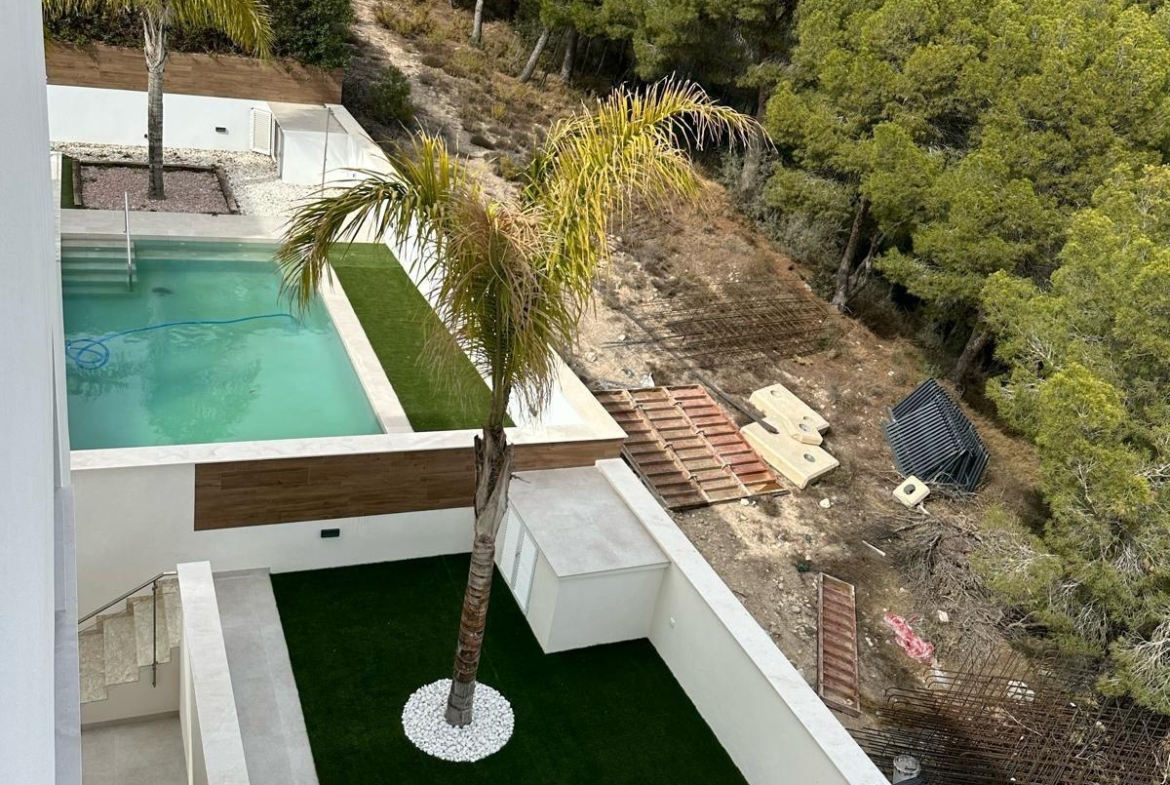 Sun-drenched modern 3-bedroom villa with private pool and landscaped terrace, nestled by lush pine trees in La Nucia, Costa Blanca.