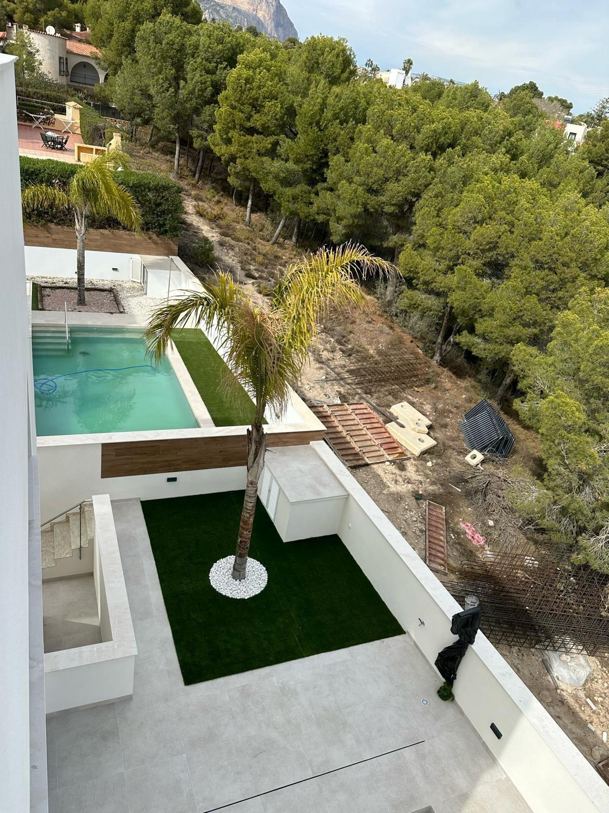 Sun-drenched modern 3-bedroom villa with private pool and landscaped terrace, nestled by lush pine trees in La Nucia, Costa Blanca.