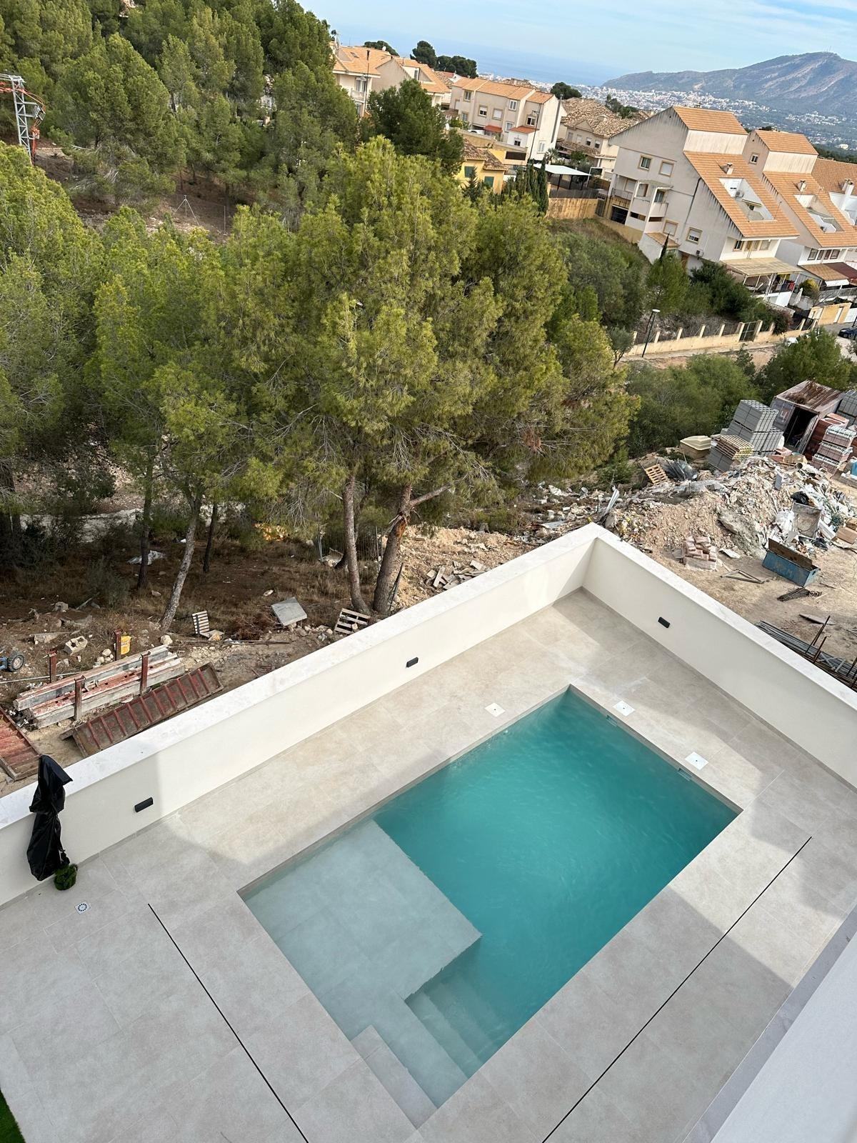 Modern new build 3 bedroom villa in La Nucia with a sleek, private rectangular pool and spacious sunlit terrace.