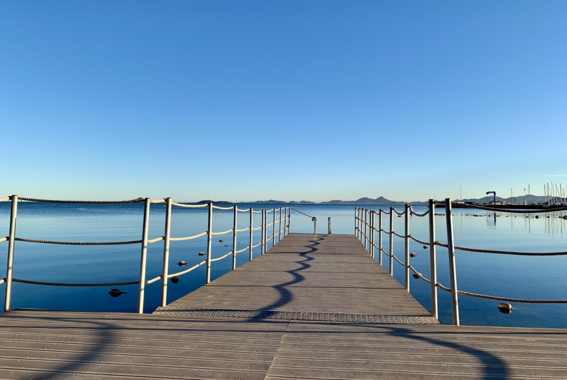 Serene waterfront view with clear blue skies and calm sea, ideal surroundings for exclusive new build villas in Los Alcázares, Murcia.