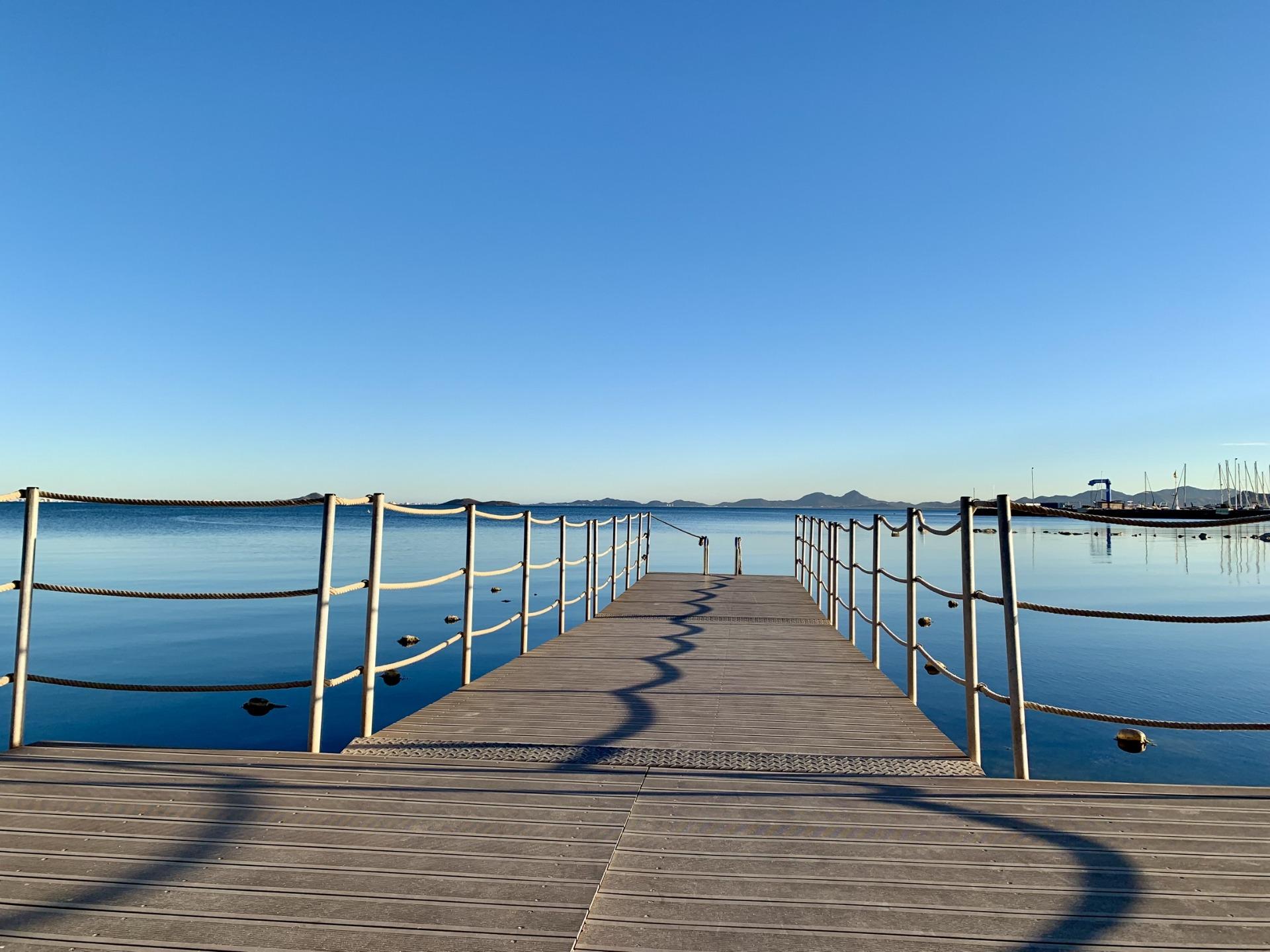 Serene waterfront view with clear blue skies and calm sea, ideal surroundings for exclusive new build villas in Los Alcázares, Murcia.