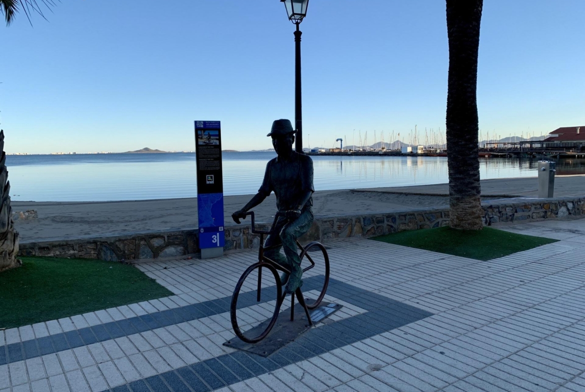 Serene waterfront promenade with artistic bicycle sculpture and calm sea views near luxury new build villas in Los Alcázares, Murcia.