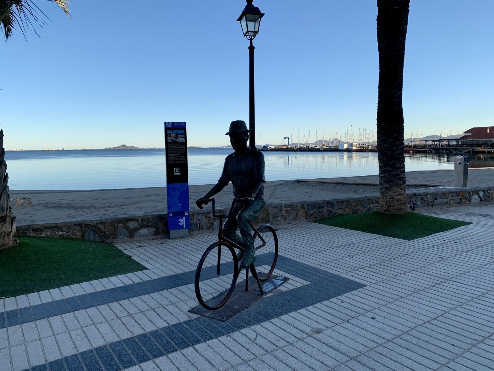 Serene waterfront promenade with artistic bicycle sculpture and calm sea views near luxury new build villas in Los Alcázares, Murcia.