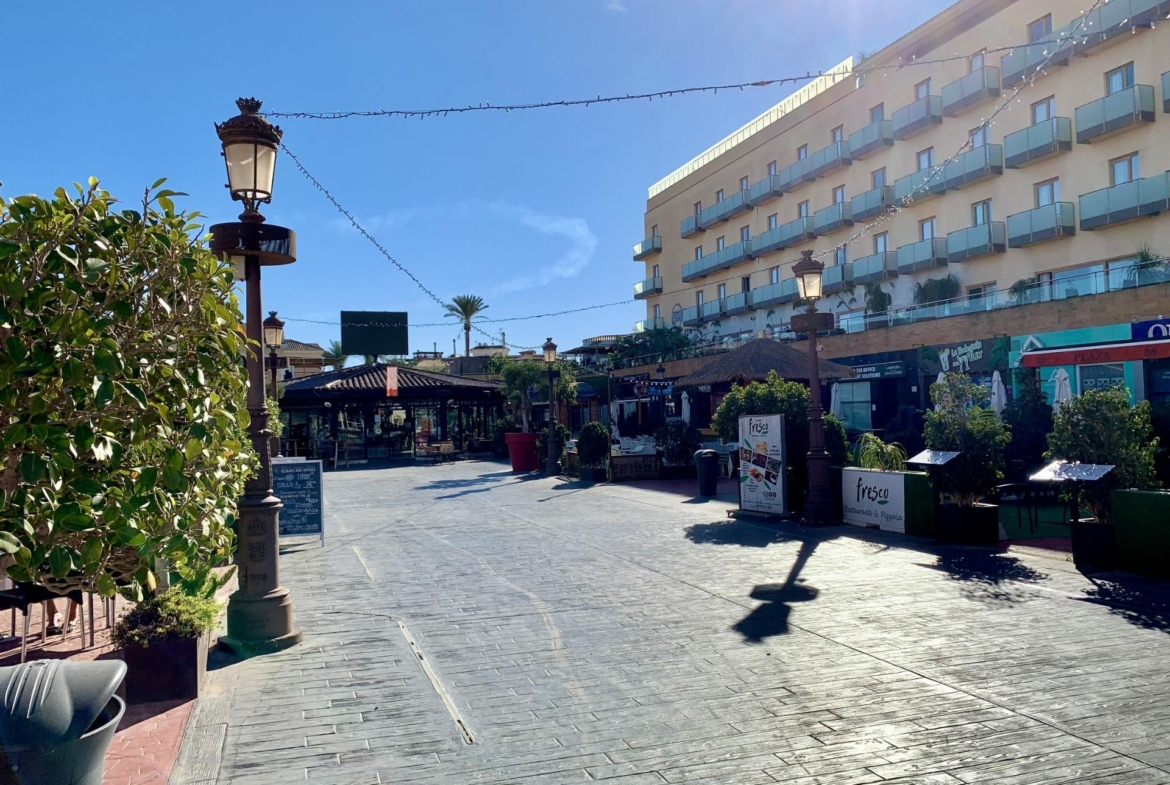 Bright sunlit street with charming cafes and modern buildings near exclusive new build villas in Los Alcázares, Murcia.