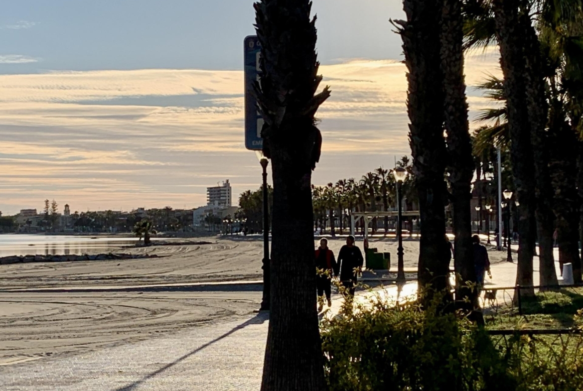 Sun-drenched beach promenade near exclusive new build villas with private pools in Los Alcázares, Murcia at sunset.