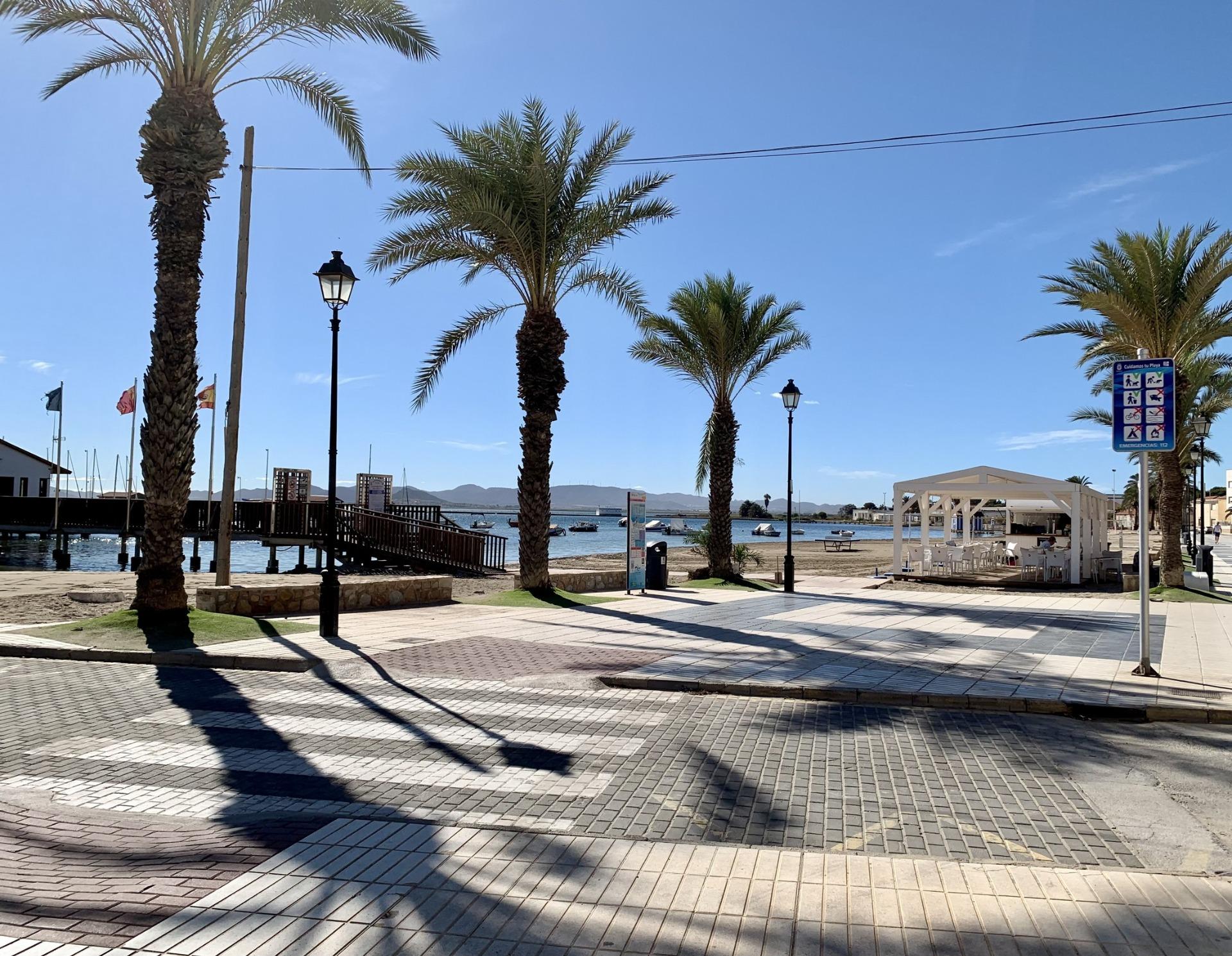 Sunlit palm-lined promenade near the beach, moments from exclusive new build villas with private pools in Los Alcázares, Murcia.