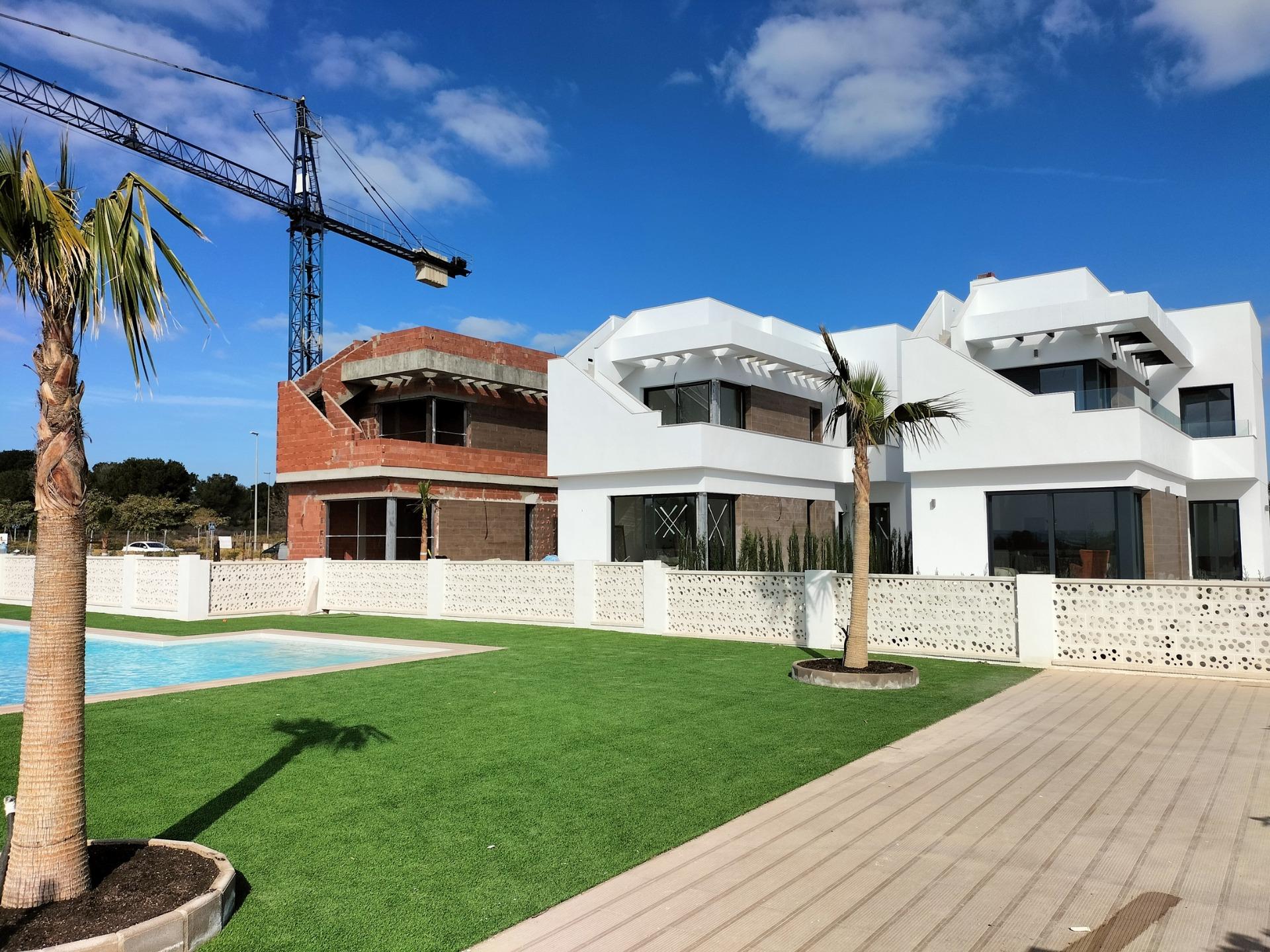 Modern, sun-drenched new build villas in Pilar de la Horadada featuring sleek white exteriors, landscaped gardens, and a private pool.