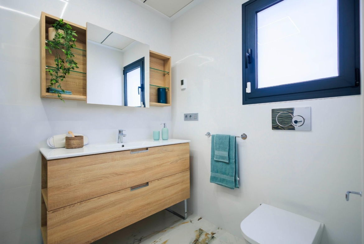 NEW-BUILD-VILLAS-IN-PILAR-DE-LA-HORADADA-ON-THE-GOLF-COURSE-14 Bright modern bathroom with sleek wooden vanity and large mirror in new build villas in Pilar de la Horadada on the golf course