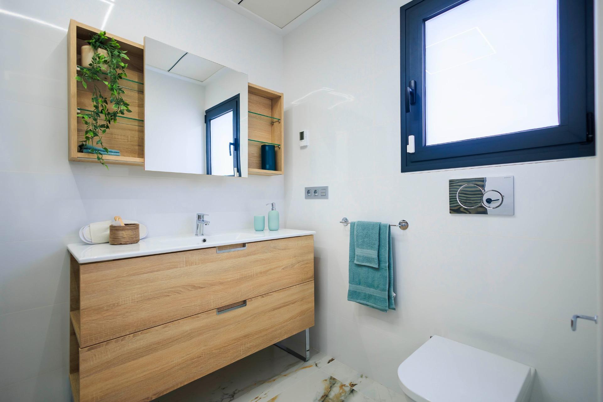 NEW-BUILD-VILLAS-IN-PILAR-DE-LA-HORADADA-ON-THE-GOLF-COURSE-14 Bright modern bathroom with sleek wooden vanity and large mirror in new build villas in Pilar de la Horadada on the golf course