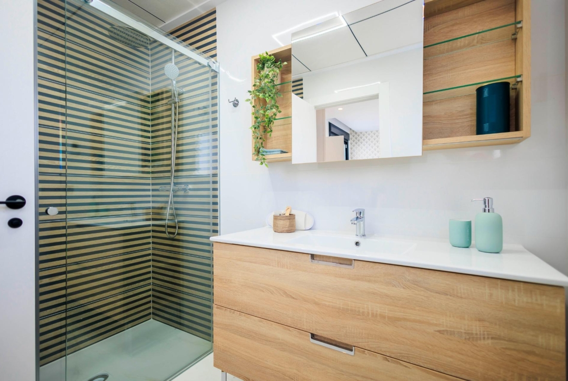 NEW-BUILD-VILLAS-IN-PILAR-DE-LA-HORADADA-ON-THE-GOLF-COURSE-15 Modern, bright bathroom with sleek wood vanity and glass shower in new build villas on Pilar de la Horadada golf course