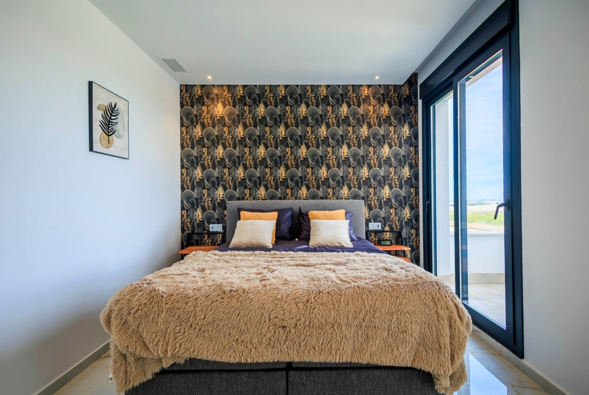 Bright modern bedroom in new build villa in Pilar de la Horadada with plush bedding and balcony overlooking the golf course