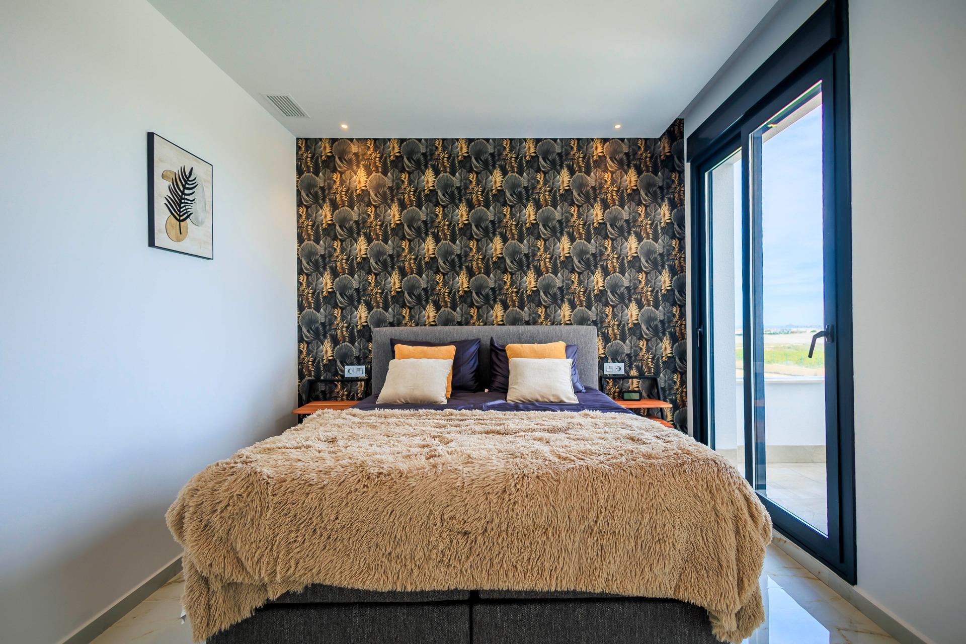 Bright modern bedroom in new build villa in Pilar de la Horadada with plush bedding and balcony overlooking the golf course