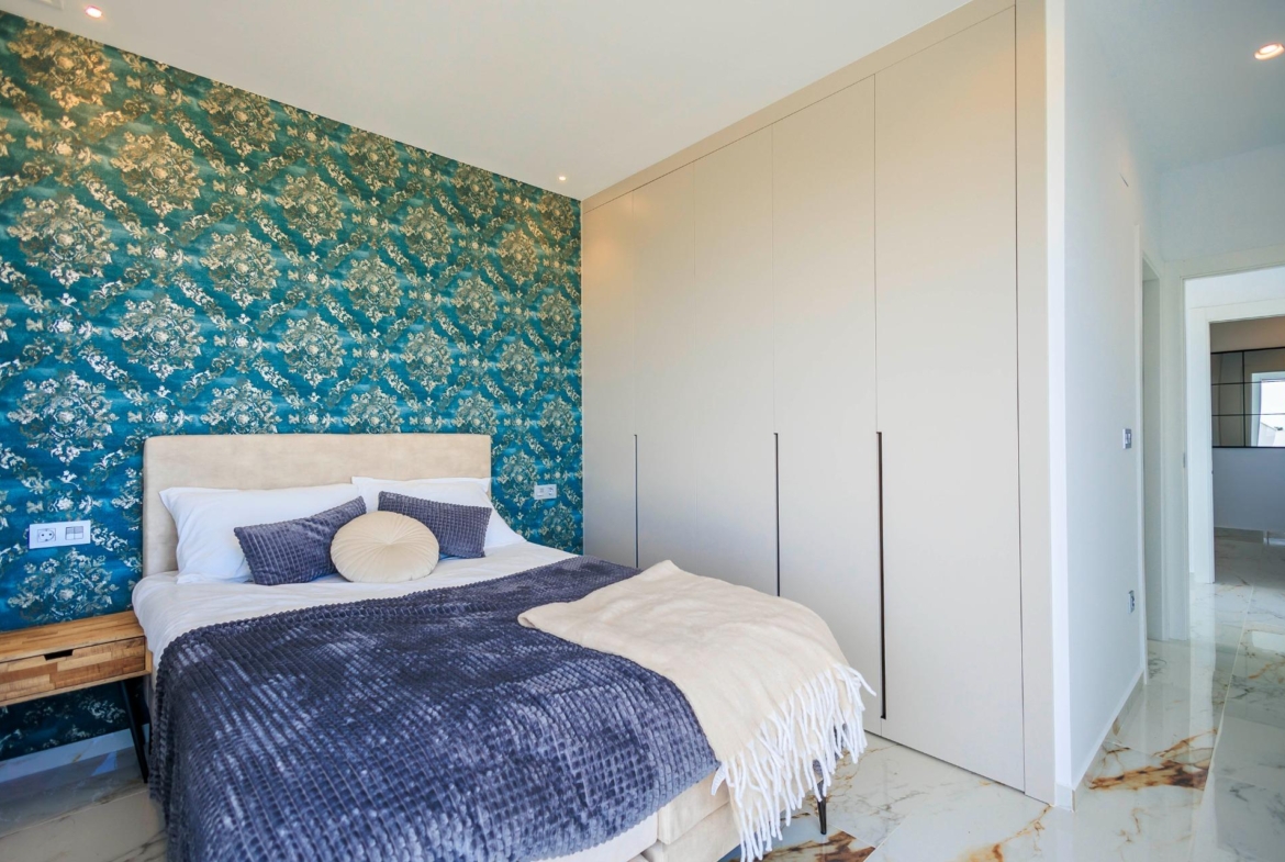 NEW-BUILD-VILLAS-IN-PILAR-DE-LA-HORADADA-ON-THE-GOLF-COURSE-25 Elegant bedroom with plush bed and patterned accent wall in new build villas in Pilar de la Horadada on the golf course