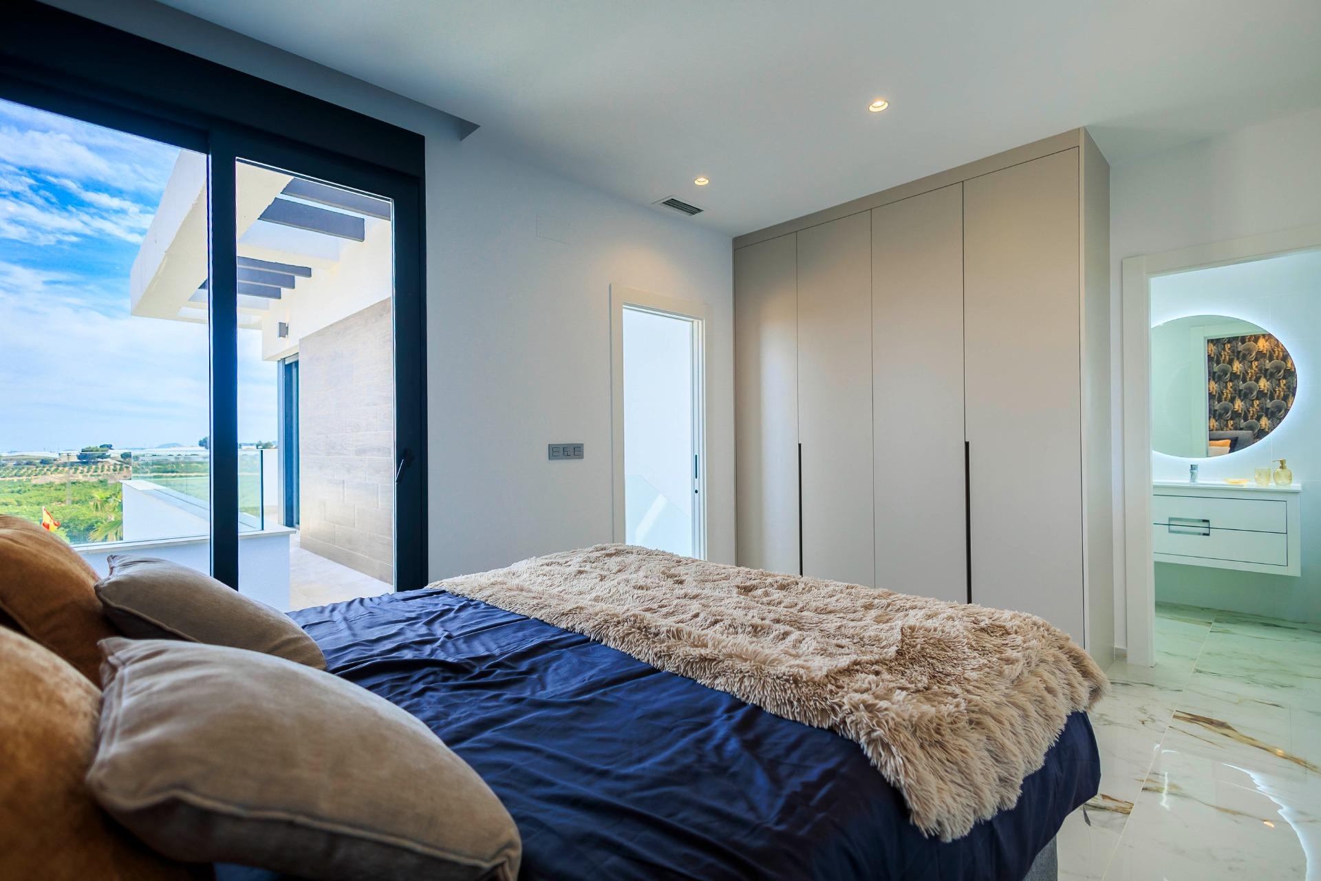 Bright modern bedroom with private terrace and golf course views in luxury new build villa in Pilar de la Horadada.