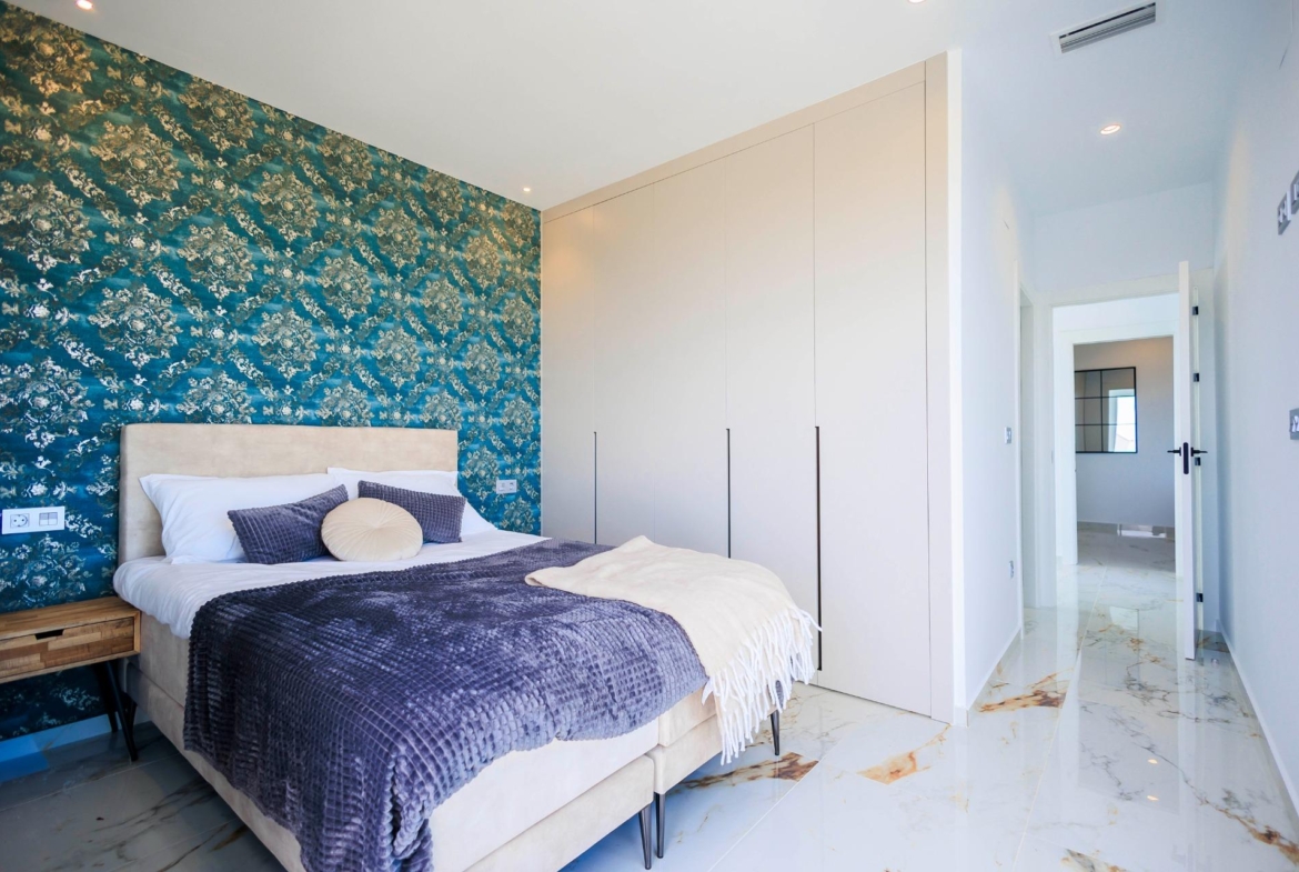 Bright and elegant bedroom with patterned feature wall and marble flooring in new build villas in Pilar de la Horadada on the golf course.