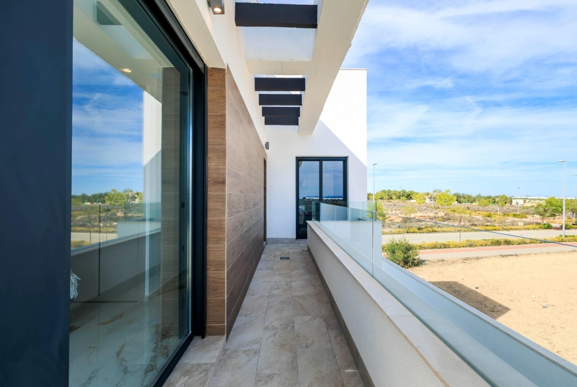 Bright modern terrace with glass railing overlooking landscaped surroundings at new build villas in Pilar de la Horadada on the golf course.