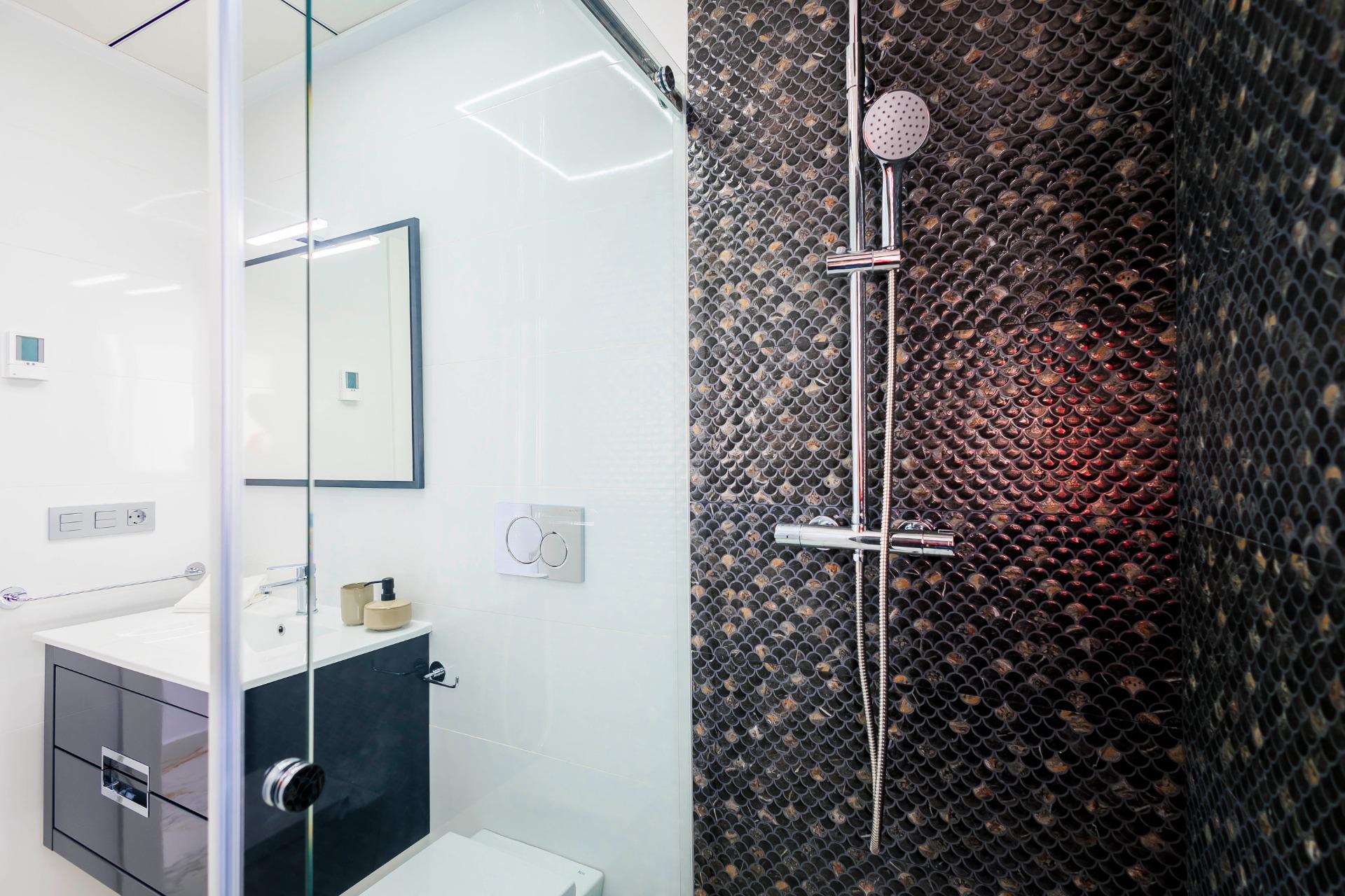 NEW-BUILD-VILLAS-IN-PILAR-DE-LA-HORADADA-ON-THE-GOLF-COURSE-34 Modern elegant bathroom with sleek fixtures and textured dark tile wall in new build villas in Pilar de la Horadada on the golf course