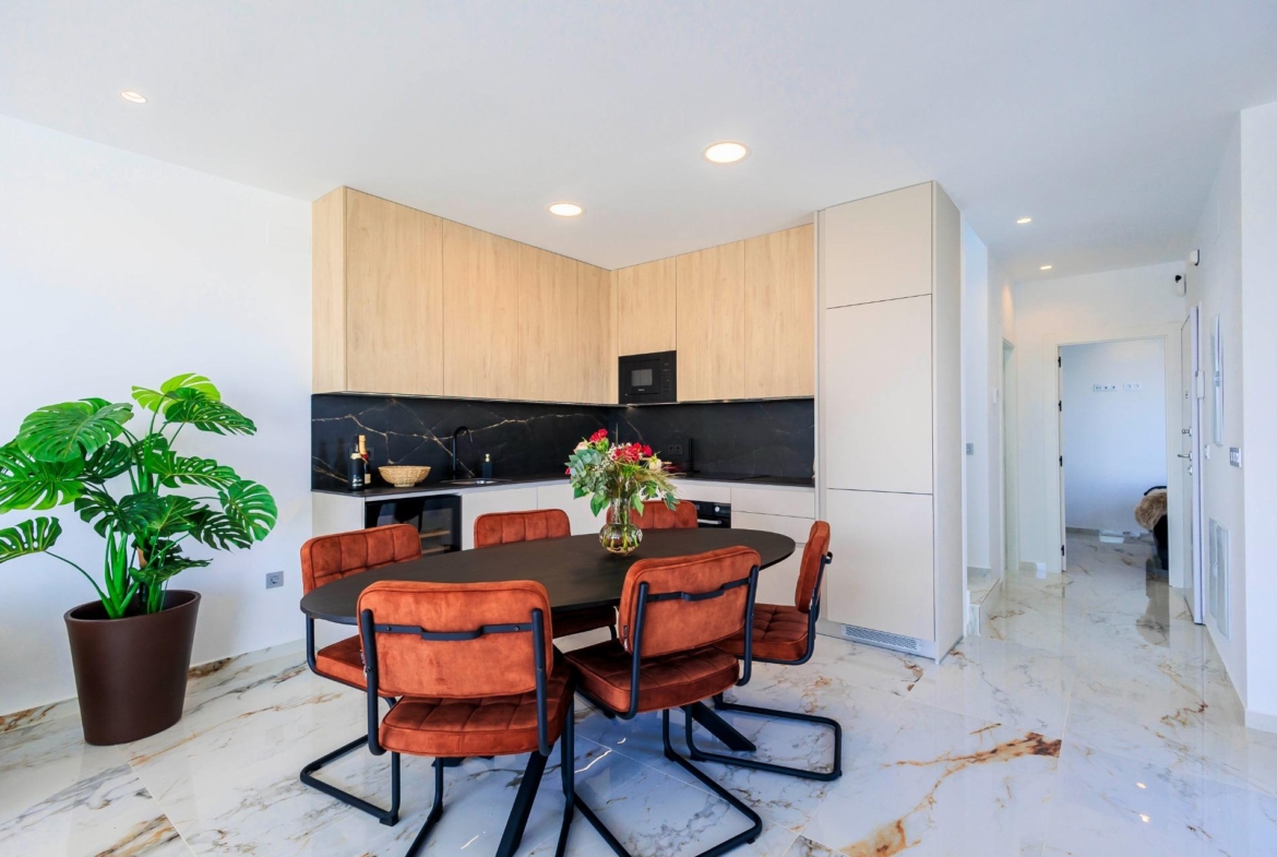 NEW-BUILD-VILLAS-IN-PILAR-DE-LA-HORADADA-ON-THE-GOLF-COURSE-37 Modern open-plan kitchen and dining area with sleek cabinetry and marble floors in new Pilar de la Horadada golf course villas