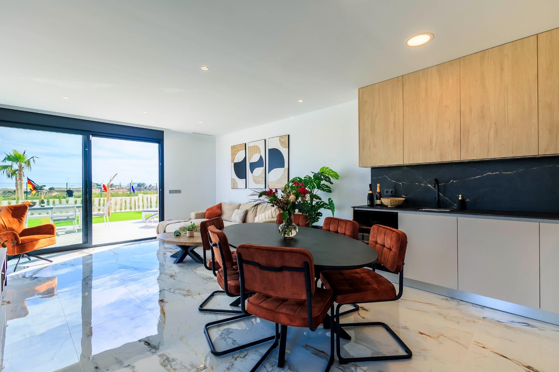 NEW-BUILD-VILLAS-IN-PILAR-DE-LA-HORADADA-ON-THE-GOLF-COURSE-42 Bright, modern dining and kitchen area with marble floors and garden views in luxury new build villas in Pilar de la Horadada on the golf course