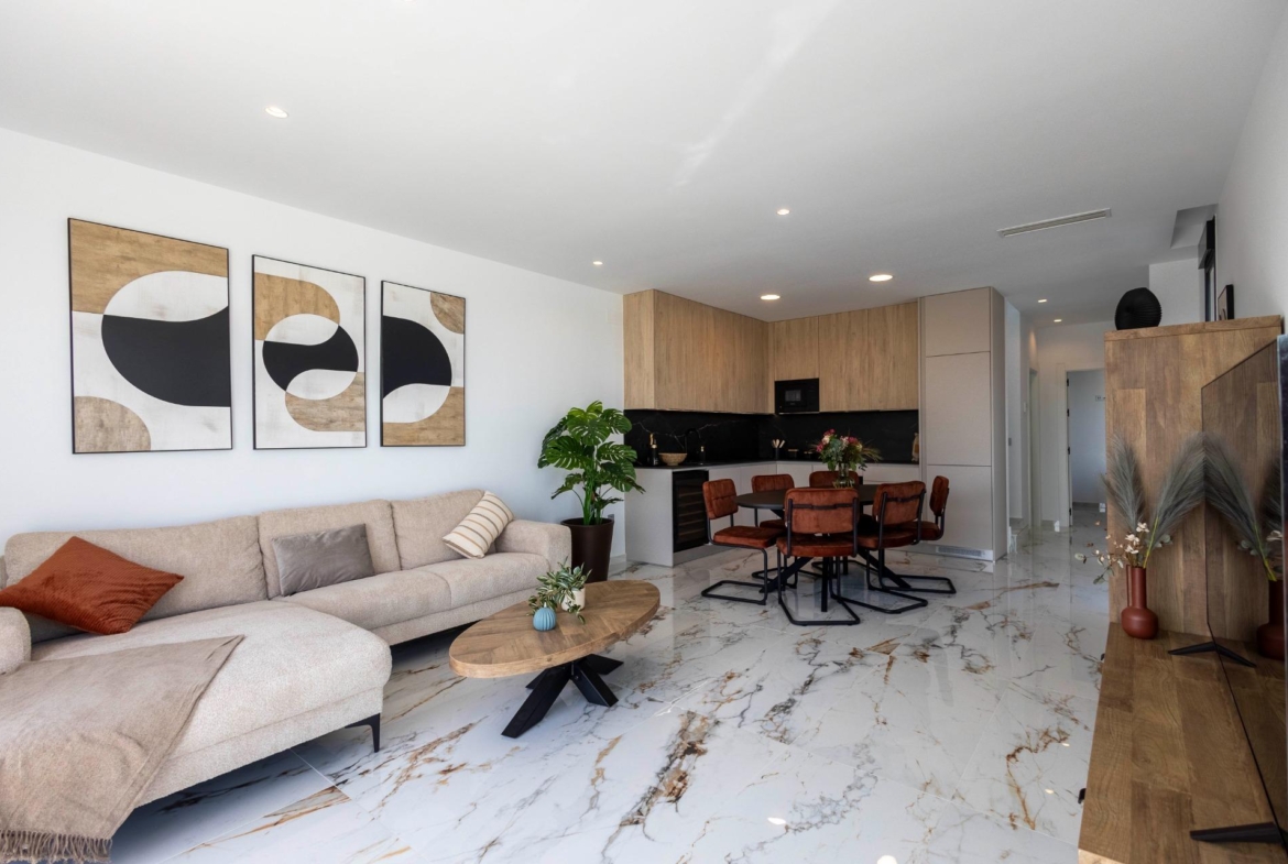 Bright, modern open-plan living and kitchen area with elegant marble flooring in new build villas in Pilar de la Horadada on the golf course