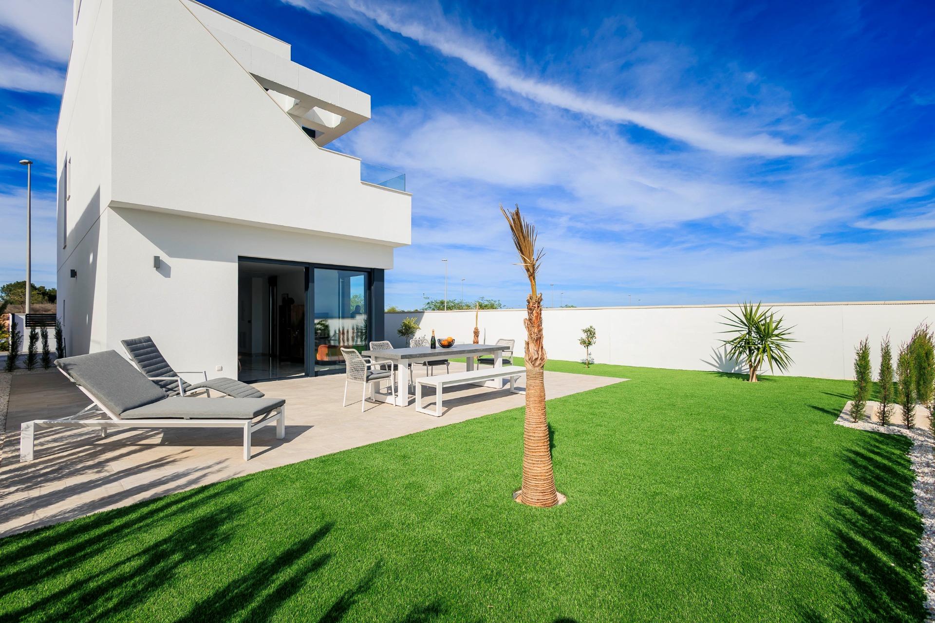 Spacious modern villa exterior with sun-drenched terrace and landscaped garden in Pilar de la Horadada on the golf course