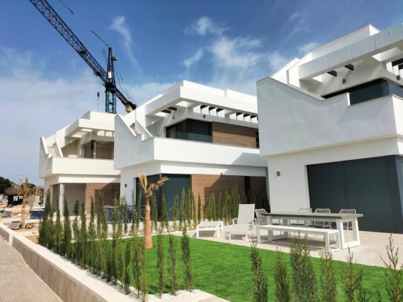 Modern luxury villas in Pilar de la Horadada with spacious terraces, stylish exterior, and landscaped gardens near the golf course.