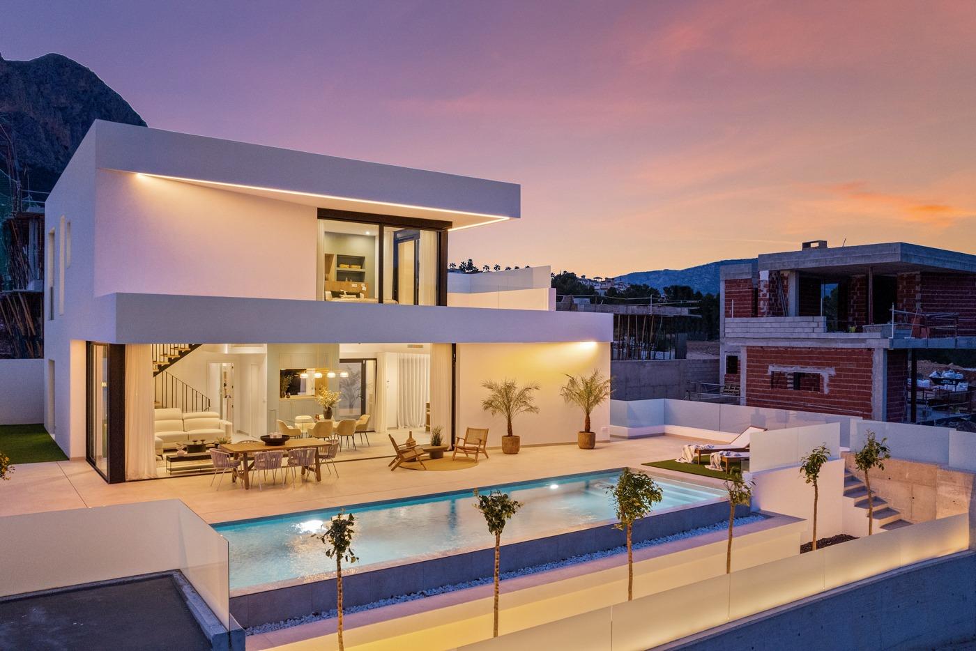 Stunning modern 3-bedroom villa in Polop with illuminated private pool, spacious terrace, and mountain backdrop at sunset.