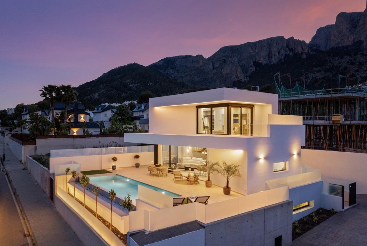 Modern sunlit 3-bedroom villa in Polop, Costa Blanca with private illuminated pool and mountain backdrop at dusk.