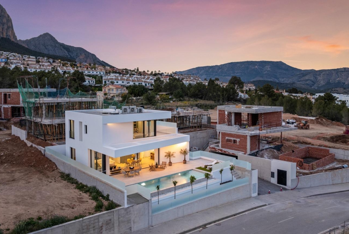 Modern 3-bedroom villa with spacious terrace and private pool at dusk, surrounded by scenic mountains in Polop, Costa Blanca.