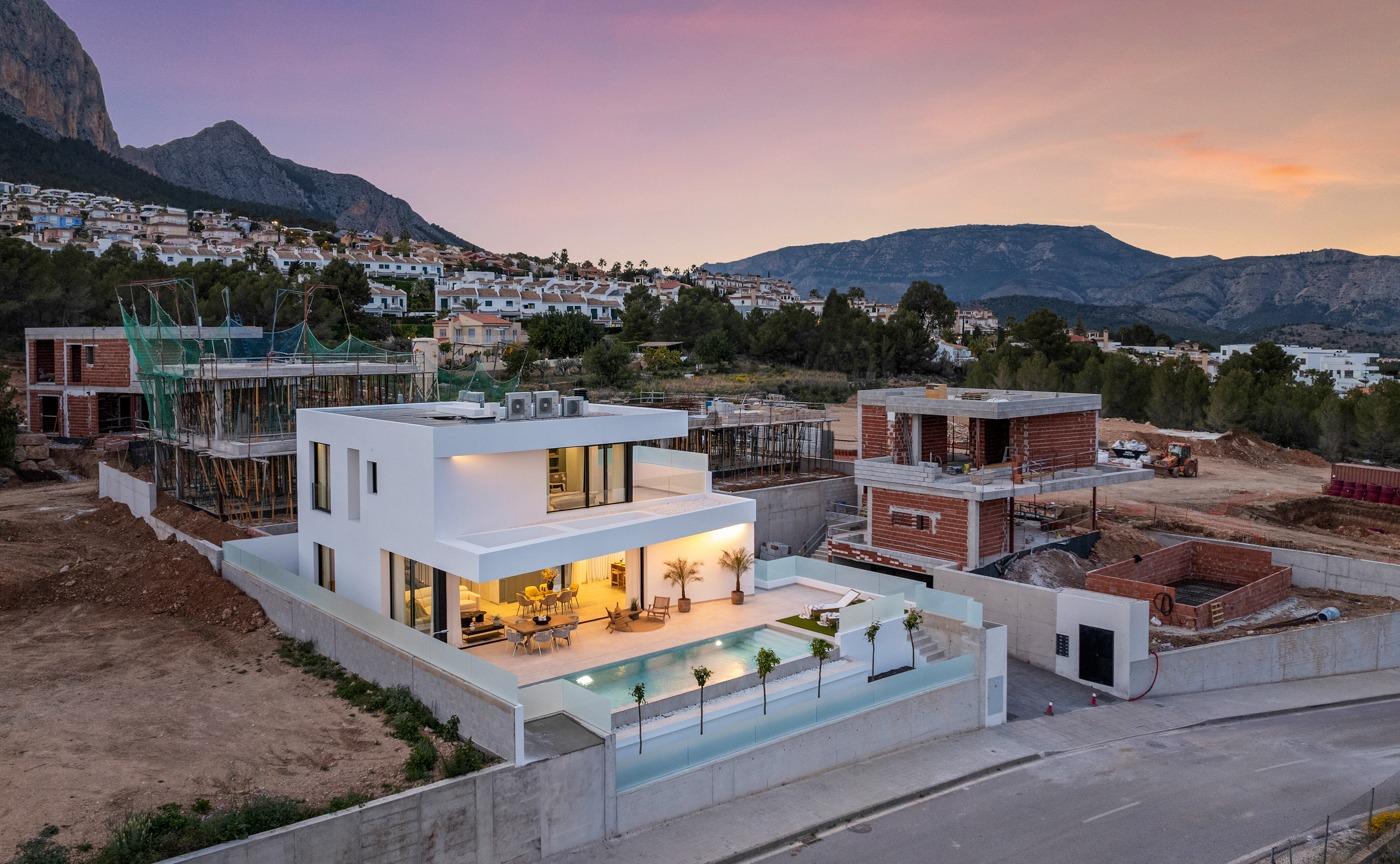 Modern 3-bedroom villa with spacious terrace and private pool at dusk, surrounded by scenic mountains in Polop, Costa Blanca.