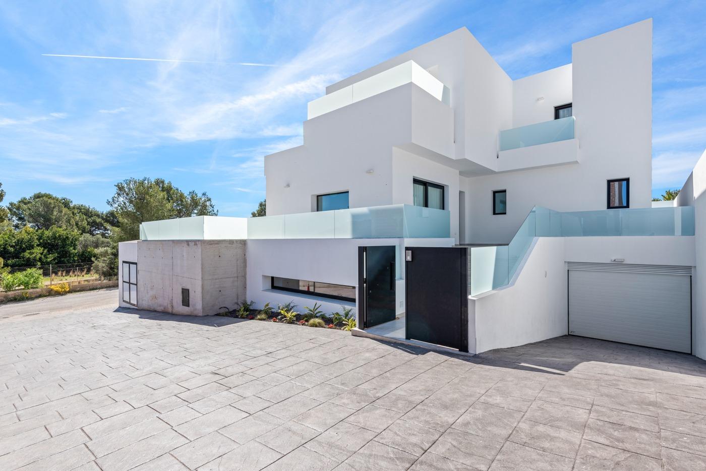 Modern three-bedroom villa with sleek white exterior and glass balconies in sunny Polop, Costa Blanca.