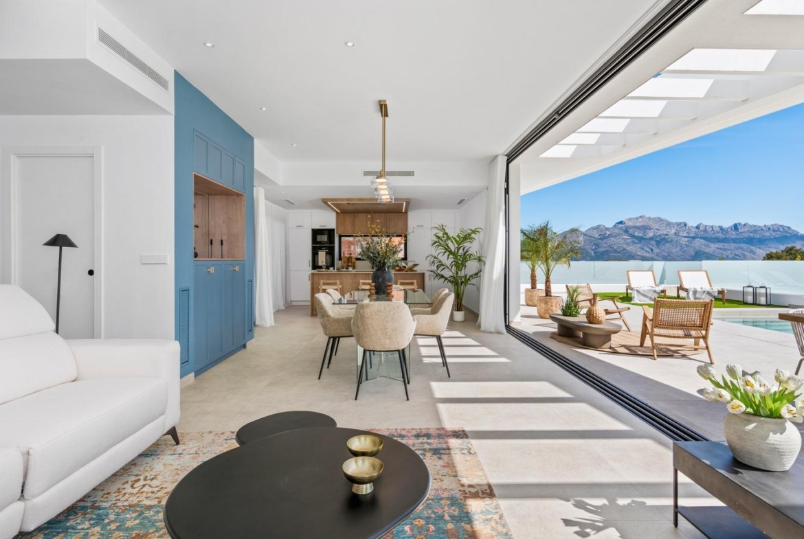 Bright open-plan living and dining area with modern kitchen, flowing to sun-drenched terrace and private pool in Polop villa.