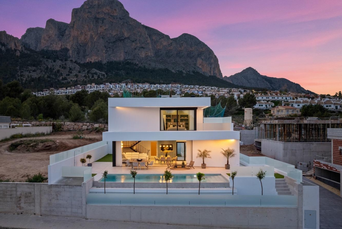 Modern 3-bedroom villa in Polop with sleek private pool, open terraces, and dramatic mountain backdrop at sunset.