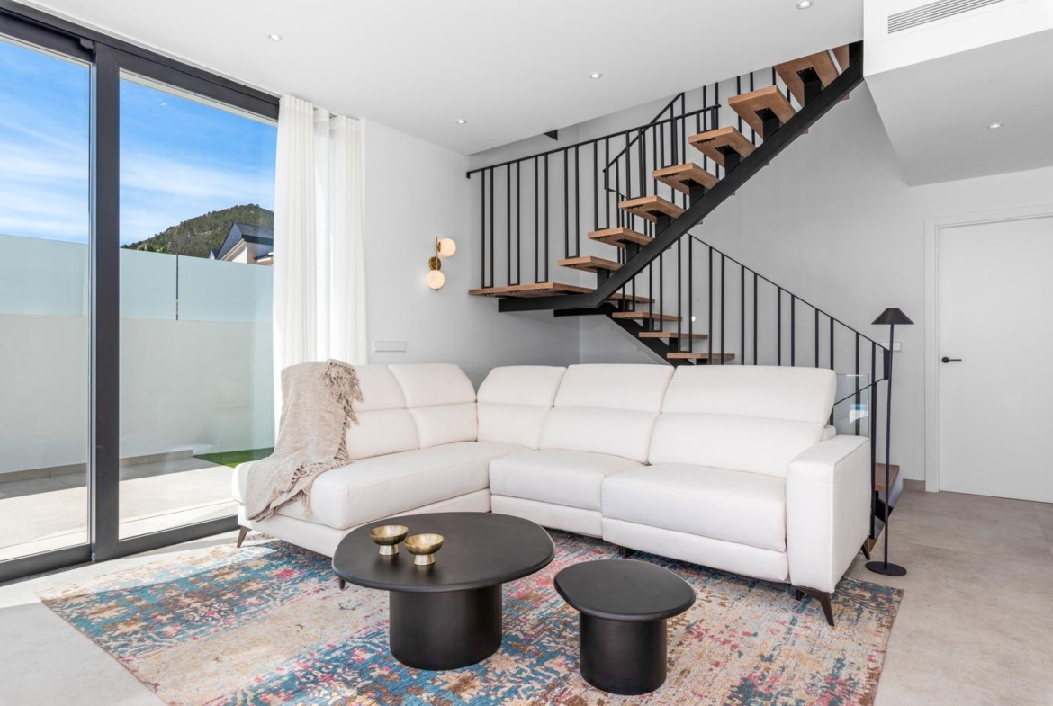 Bright and modern living room with sleek staircase and sliding glass doors in a luxury 3-bedroom villa in Polop, Costa Blanca.