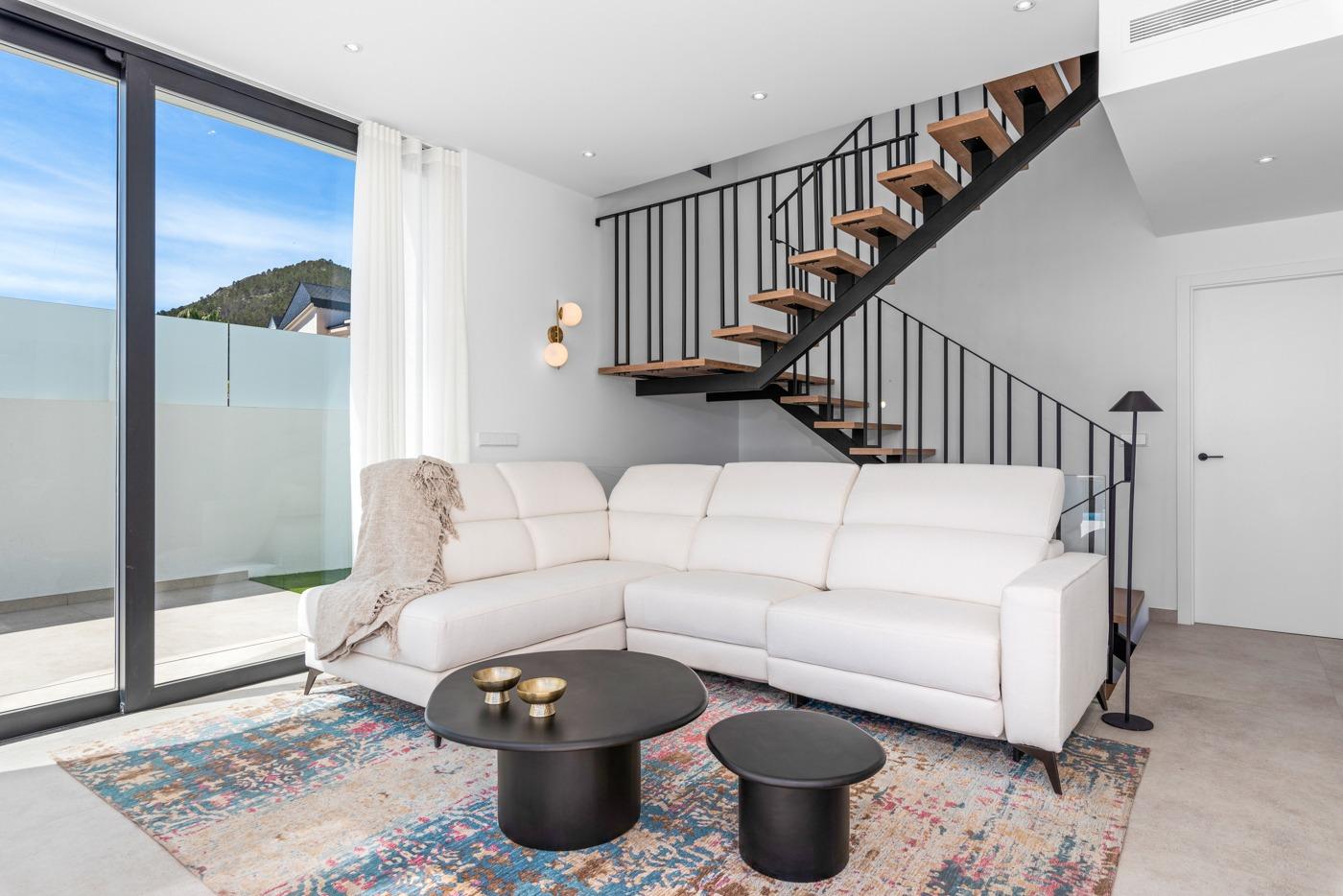 Bright and modern living room with sleek staircase and sliding glass doors in a luxury 3-bedroom villa in Polop, Costa Blanca.