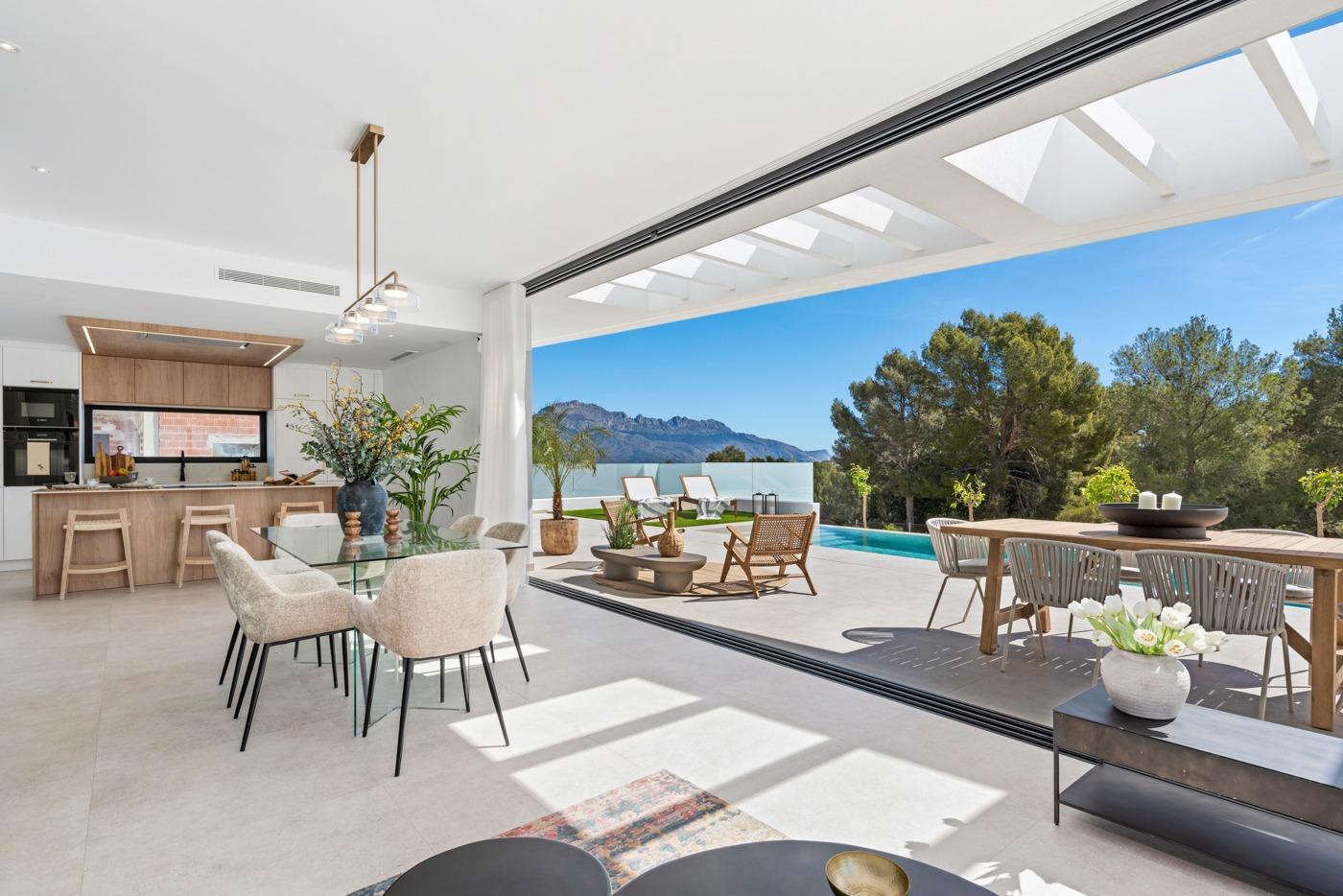 Bright open-plan dining and kitchen area with seamless access to a sun-drenched terrace and private pool in Polop villa.