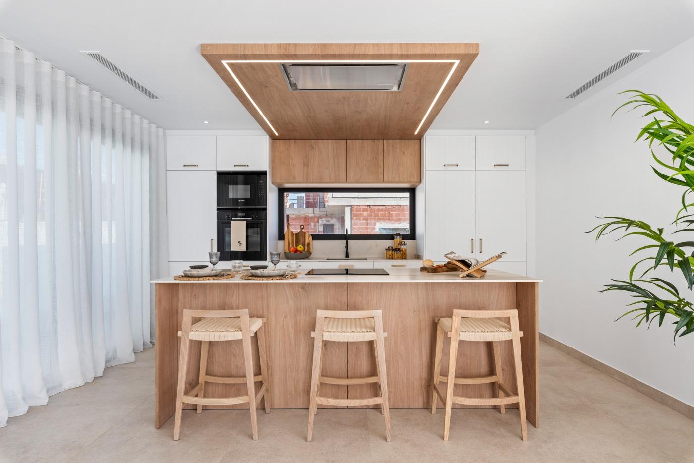 Bright modern kitchen with wood accents and sleek appliances in a new 3-bedroom villa in Polop, Costa Blanca.