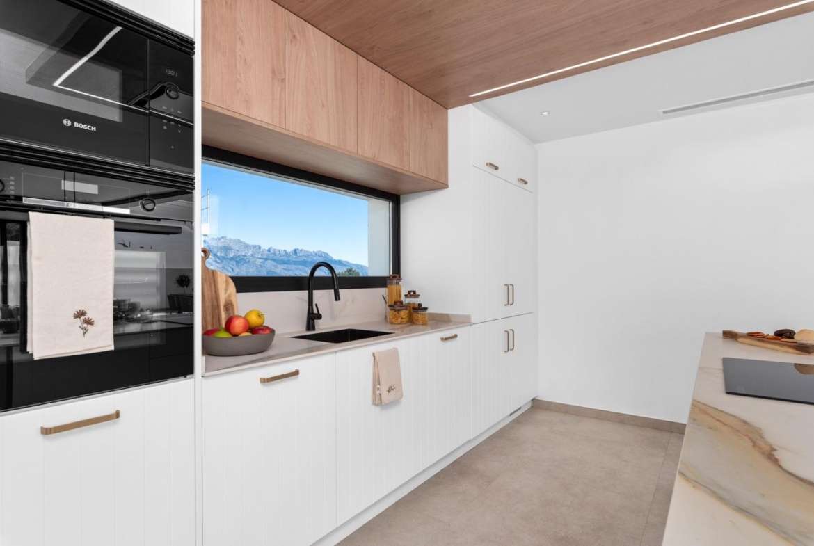 Bright modern kitchen with sleek appliances and panoramic mountain views in luxury 3-bedroom villa in Polop, Costa Blanca