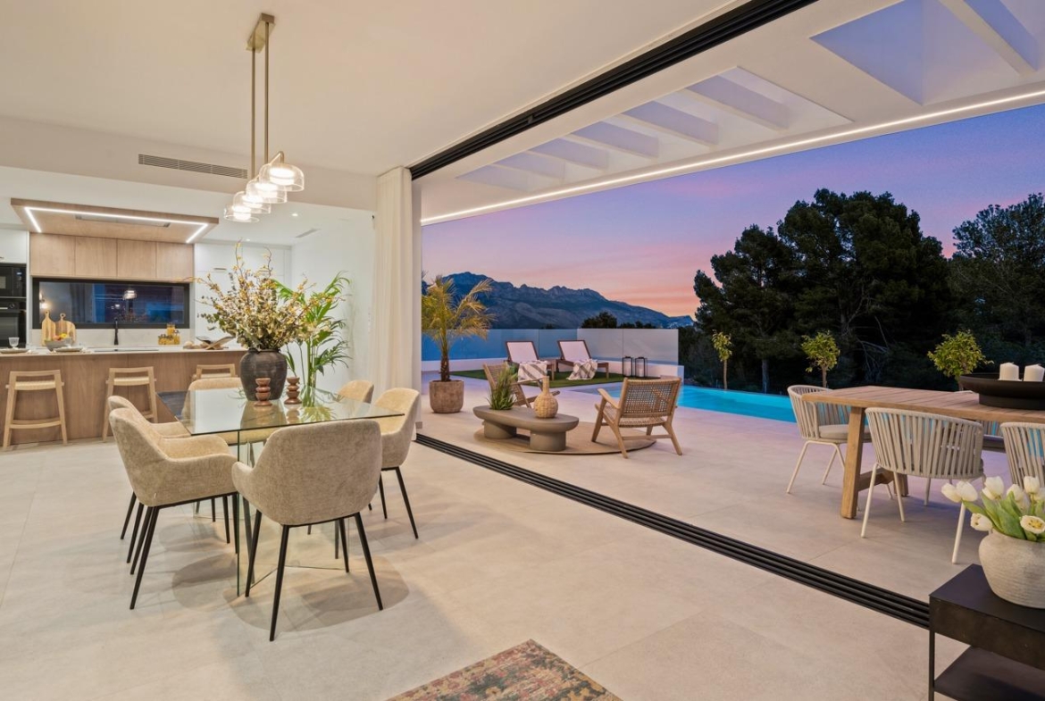 Spacious open-plan dining and kitchen area flowing to a terrace with private pool and mountain views in a modern 3-bedroom villa in Polop, Costa Blanca