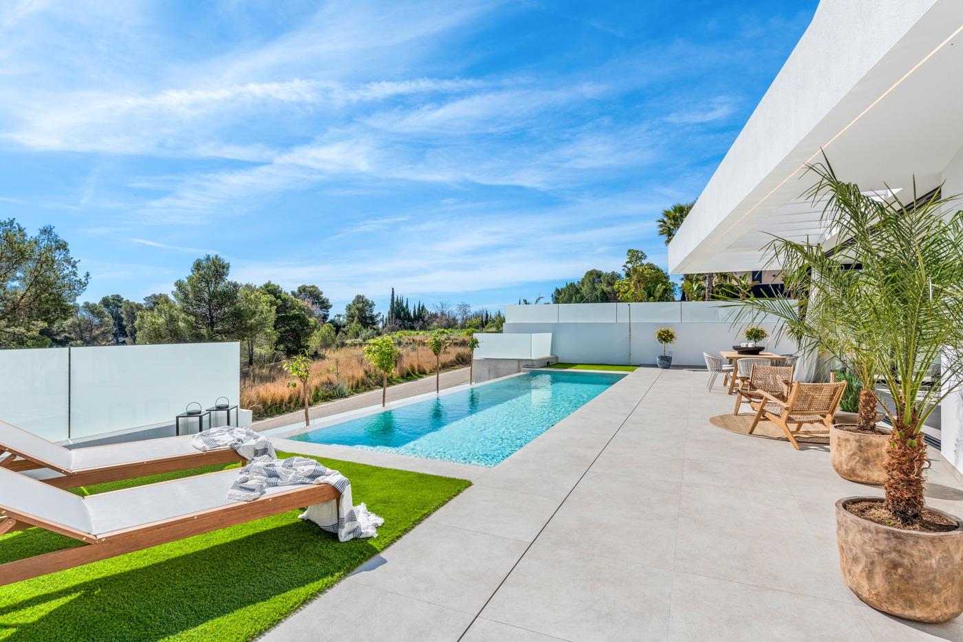 Sun-drenched modern terrace with private pool and lush greenery at a new 3-bedroom villa in Polop, Costa Blanca.