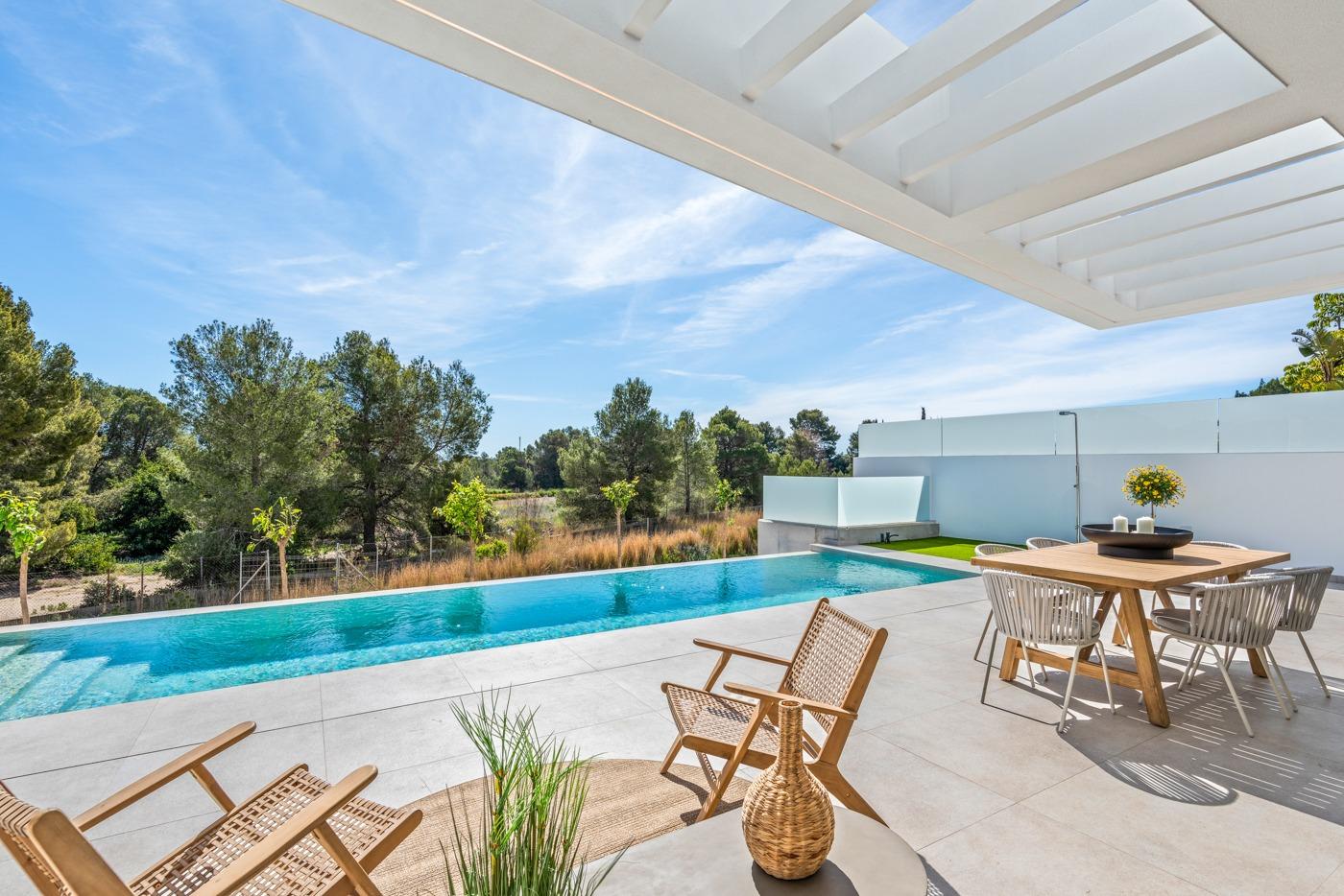 Sun-drenched terrace with modern outdoor dining and lounging area overlooking a private pool at a 3-bedroom villa in Polop, Costa Blanca