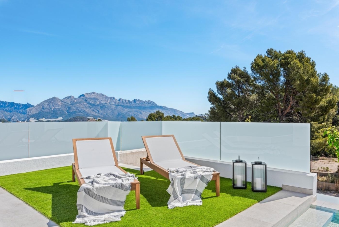Sun-drenched terrace with modern loungers and mountain views at the impressive new build 3-bedroom villa in Polop, Costa Blanca