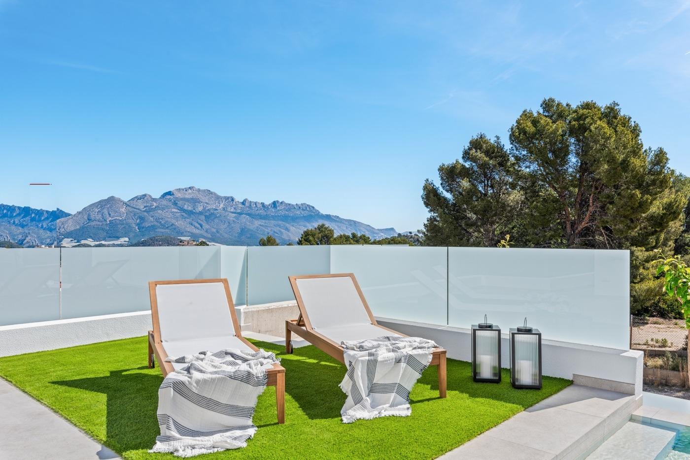 Sun-drenched terrace with modern loungers and mountain views at the impressive new build 3-bedroom villa in Polop, Costa Blanca