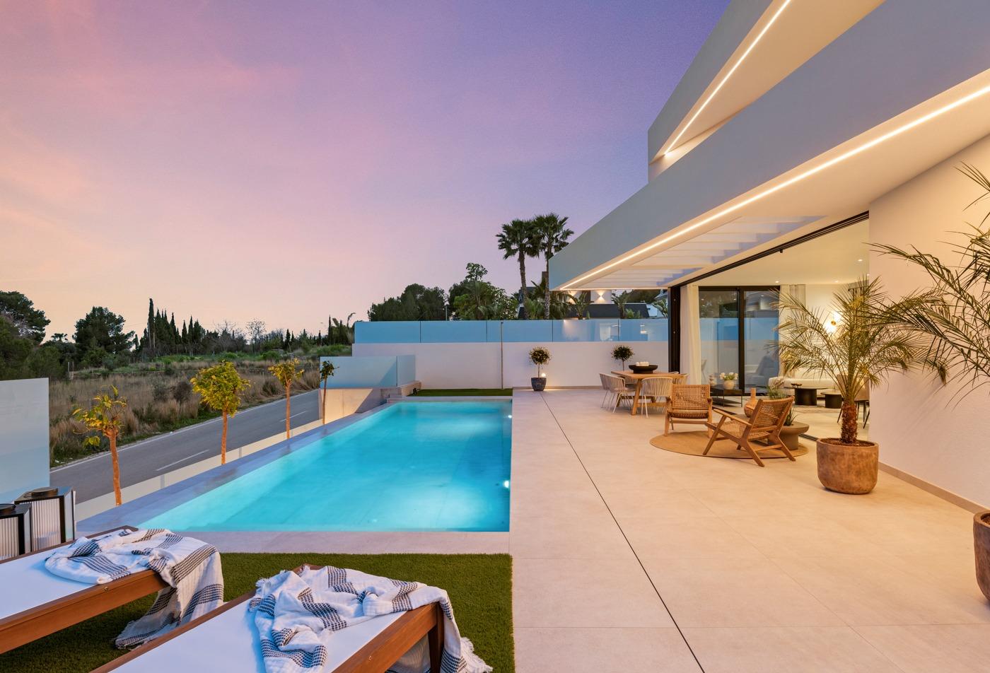 Sunset-lit private pool and sleek terrace of modern 3-bedroom villa in Polop, Costa Blanca with stylish outdoor seating and lush surroundings.