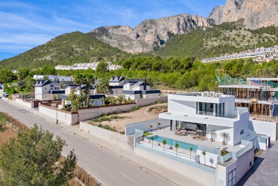 Modern three-bedroom villa with private pool and spacious terrace set against lush mountainous backdrop in Polop, Costa Blanca.