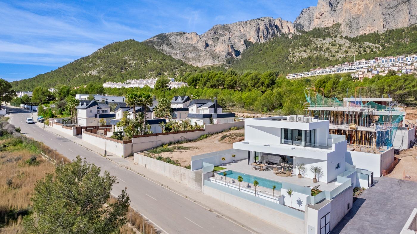 Modern three-bedroom villa with private pool and spacious terrace set against lush mountainous backdrop in Polop, Costa Blanca.