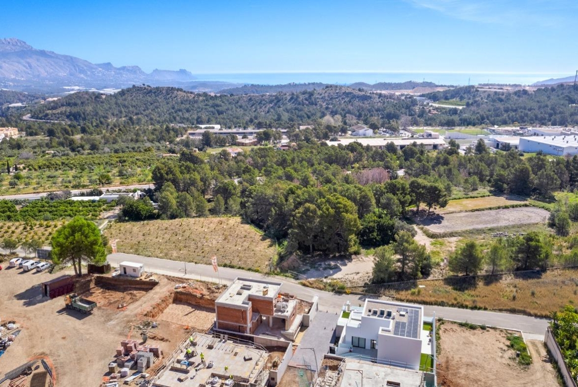 Aerial view of a modern new build 3 bedroom villa with spacious terraces in a peaceful Polop, Costa Blanca landscape.