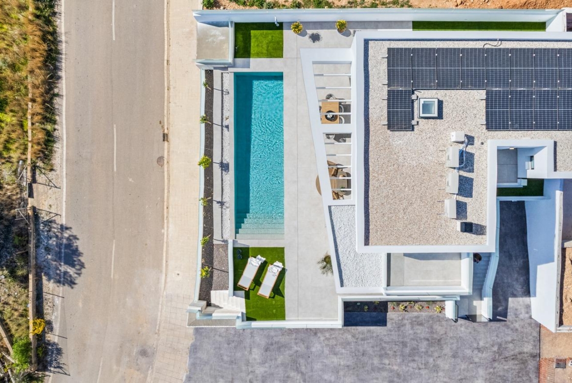 Aerial view of a modern 3-bedroom villa in Polop with a private turquoise pool, sun-drenched terrace, and sleek solar panels